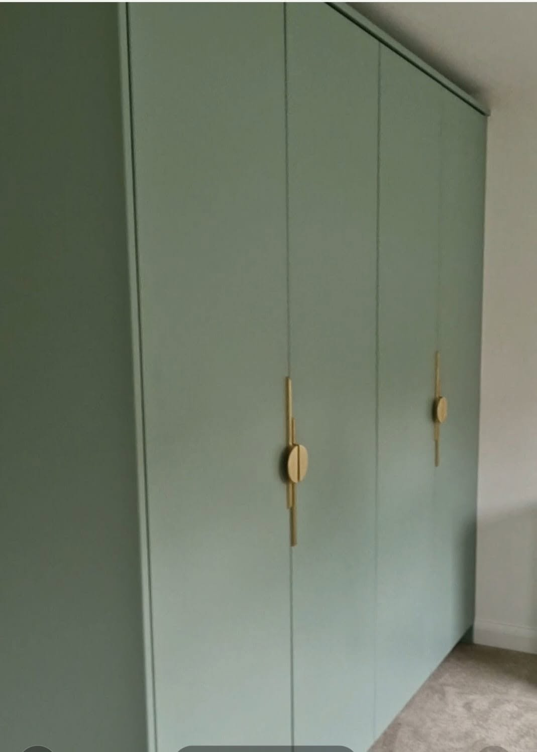 Floor-to-ceiling fitted wardrobe with brass handles